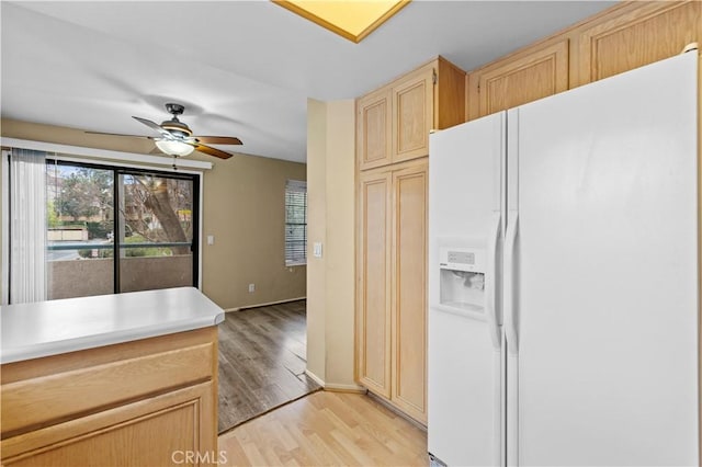 kitchen with light hardwood / wood-style flooring, white refrigerator with ice dispenser, ceiling fan, and light brown cabinets