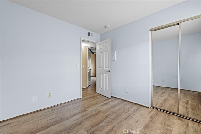 unfurnished bedroom featuring light hardwood / wood-style floors and a closet