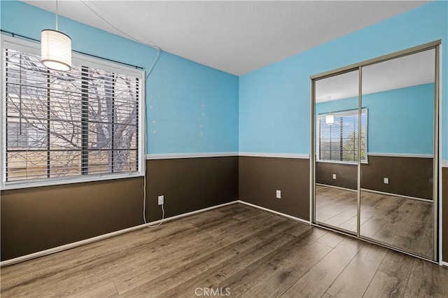 unfurnished bedroom with wood-type flooring and a closet