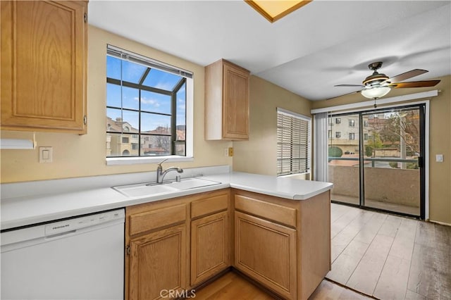 kitchen with white dishwasher, sink, light hardwood / wood-style floors, and kitchen peninsula