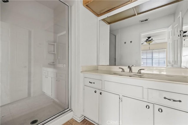 bathroom featuring vanity, a shower with shower door, and ceiling fan