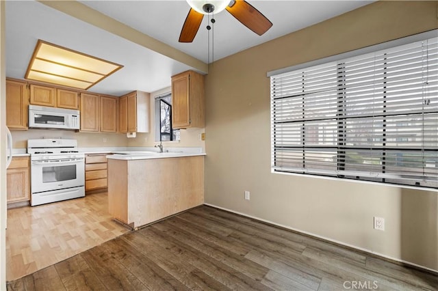 kitchen with hardwood / wood-style floors, light brown cabinetry, ceiling fan, kitchen peninsula, and white appliances