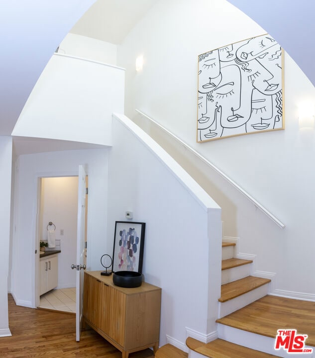 stairs featuring hardwood / wood-style floors