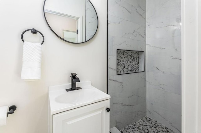 bathroom featuring vanity and tiled shower