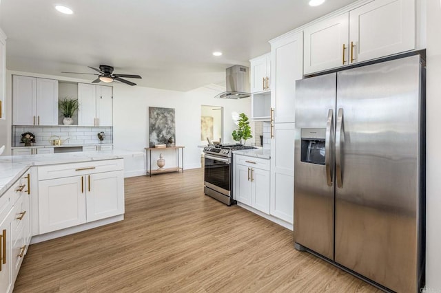 kitchen with white cabinets, exhaust hood, light hardwood / wood-style floors, stainless steel appliances, and light stone countertops