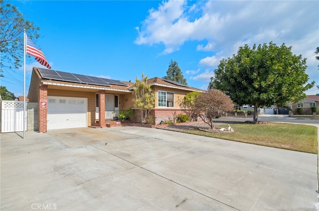 single story home with a garage, a front lawn, and solar panels