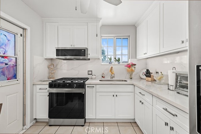 kitchen featuring tasteful backsplash, appliances with stainless steel finishes, sink, and white cabinets