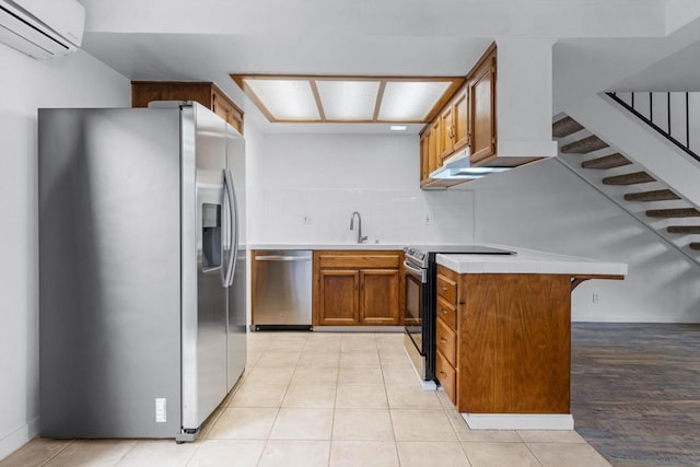 kitchen with sink, backsplash, stainless steel appliances, a wall mounted AC, and kitchen peninsula