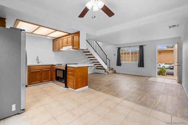 kitchen featuring sink, light hardwood / wood-style flooring, kitchen peninsula, ceiling fan, and stainless steel appliances