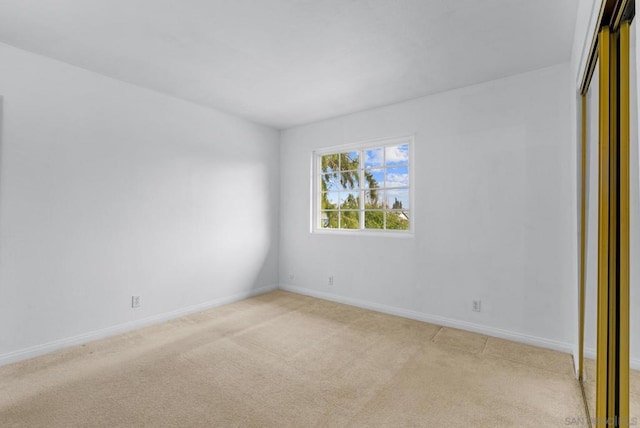 unfurnished bedroom featuring light carpet and a closet