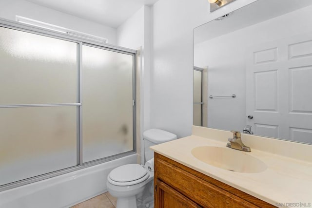 full bathroom with vanity, tile patterned floors, toilet, and combined bath / shower with glass door