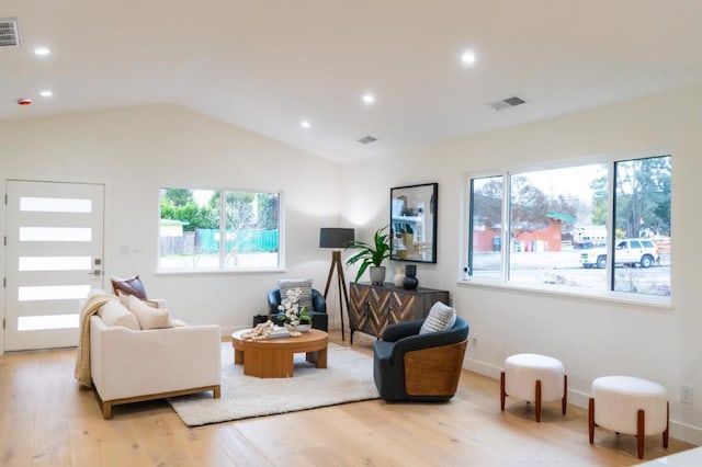 living room featuring lofted ceiling and light hardwood / wood-style flooring