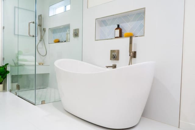 bathroom featuring separate shower and tub