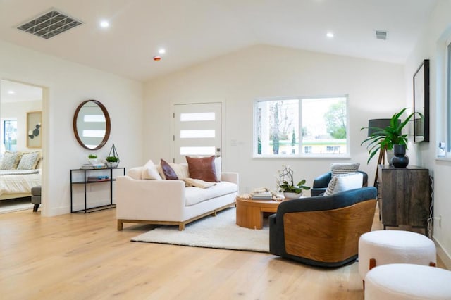 living room featuring vaulted ceiling and light hardwood / wood-style flooring