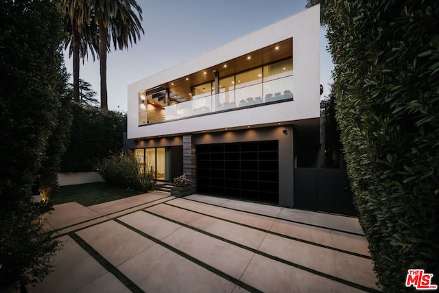 contemporary home featuring a garage and a balcony