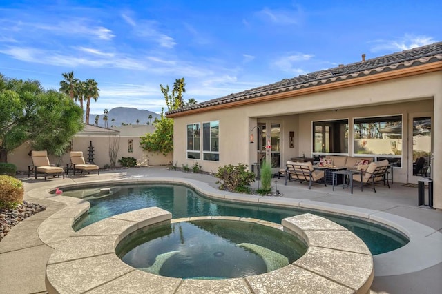 view of pool with an outdoor living space, a patio area, a mountain view, and an in ground hot tub