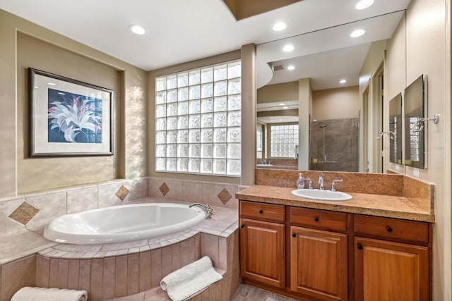 bathroom featuring independent shower and bath and vanity