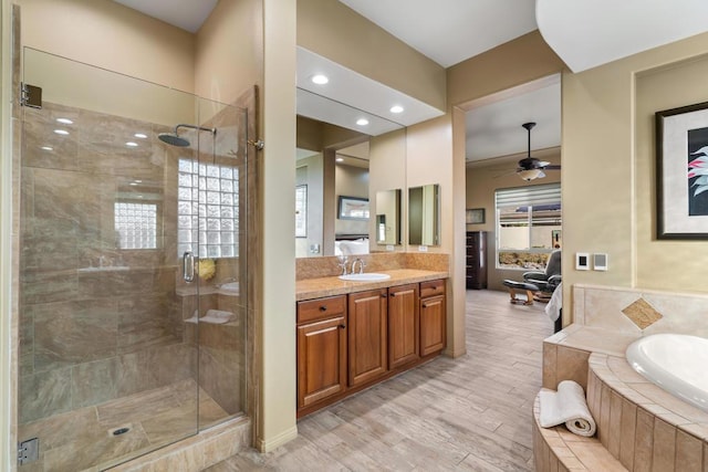 bathroom with ceiling fan, vanity, shower with separate bathtub, and hardwood / wood-style floors