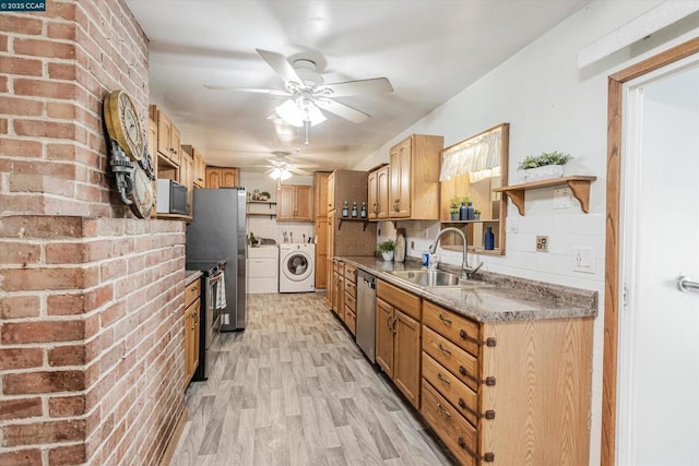 kitchen with sink, ceiling fan, stainless steel appliances, independent washer and dryer, and light hardwood / wood-style floors