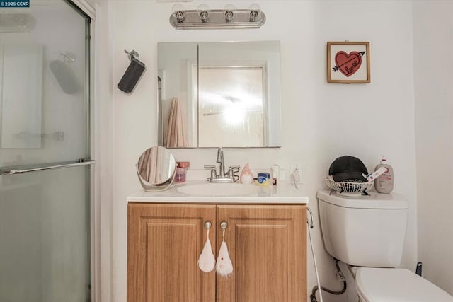 bathroom with vanity, a shower with shower door, and toilet