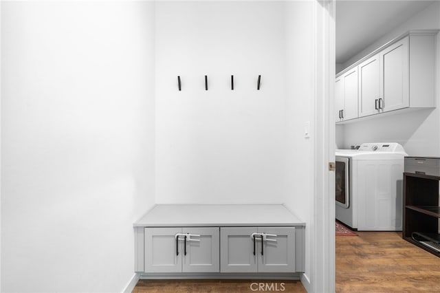 laundry room featuring dark hardwood / wood-style flooring, cabinets, and washer and dryer