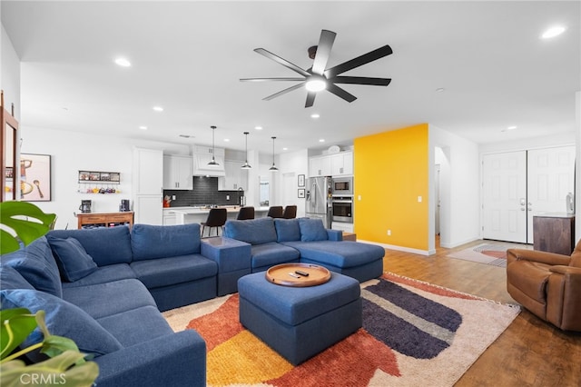 living room featuring ceiling fan and light hardwood / wood-style floors