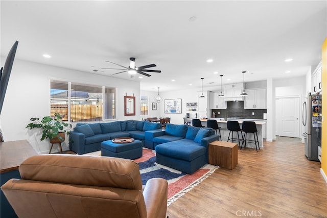 living room with ceiling fan and light wood-type flooring