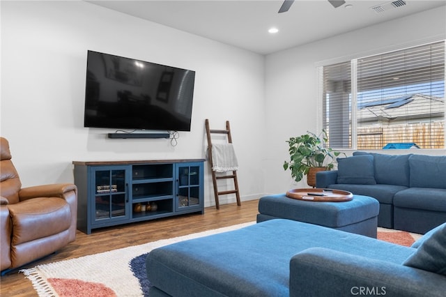 living room featuring wood-type flooring and ceiling fan