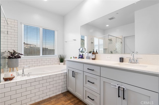 bathroom with vanity, hardwood / wood-style floors, and independent shower and bath