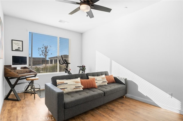 living room featuring wood-type flooring and ceiling fan