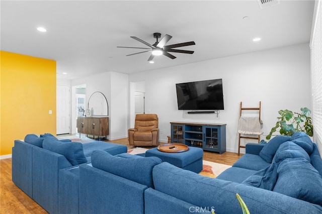 living room featuring ceiling fan and light hardwood / wood-style flooring