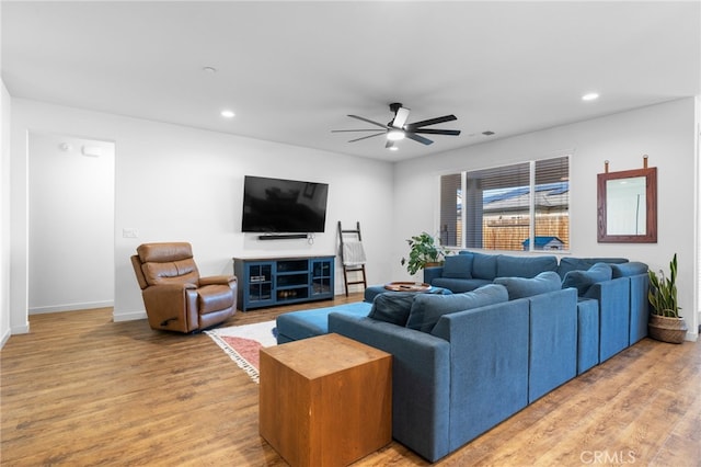 living room featuring hardwood / wood-style floors and ceiling fan