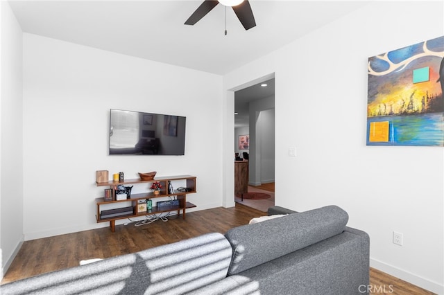 living room featuring dark hardwood / wood-style flooring and ceiling fan