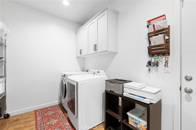 laundry room featuring cabinets, independent washer and dryer, and light hardwood / wood-style floors