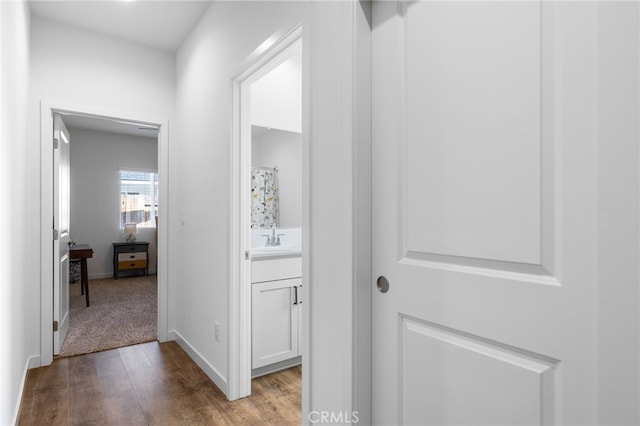 hallway with sink and light hardwood / wood-style floors