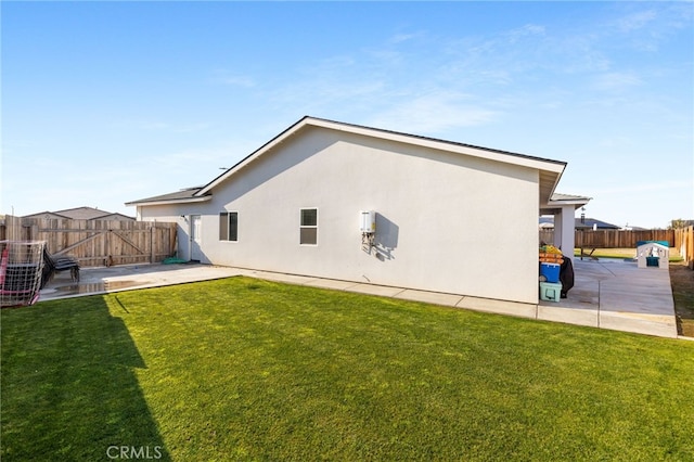 rear view of house featuring a yard and a patio area