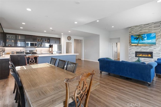 dining room featuring a large fireplace and hardwood / wood-style floors