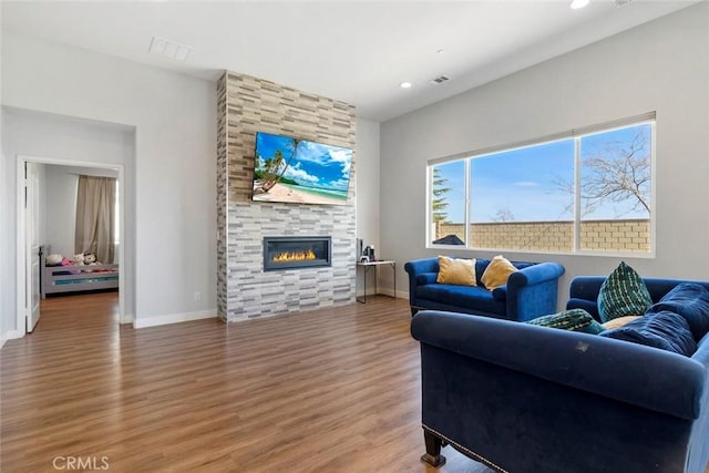 living room with hardwood / wood-style flooring and a fireplace