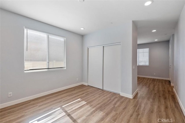 unfurnished bedroom with light hardwood / wood-style floors and a closet