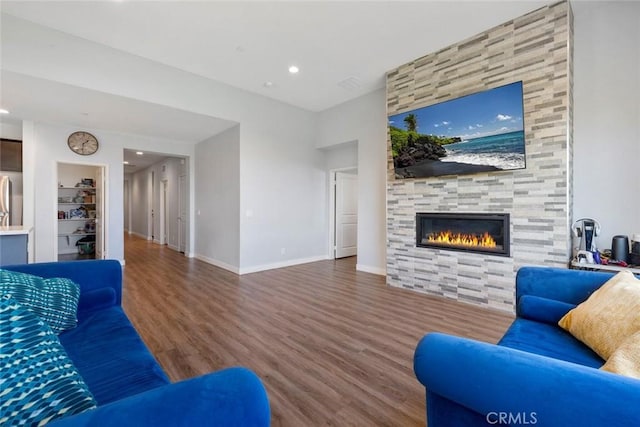 living room with a tile fireplace and wood-type flooring