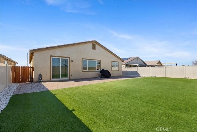 back of property with a patio and a lawn