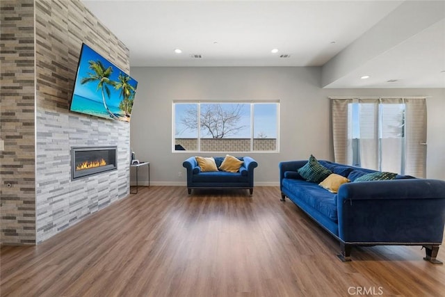 living room featuring hardwood / wood-style flooring, a wealth of natural light, and a fireplace