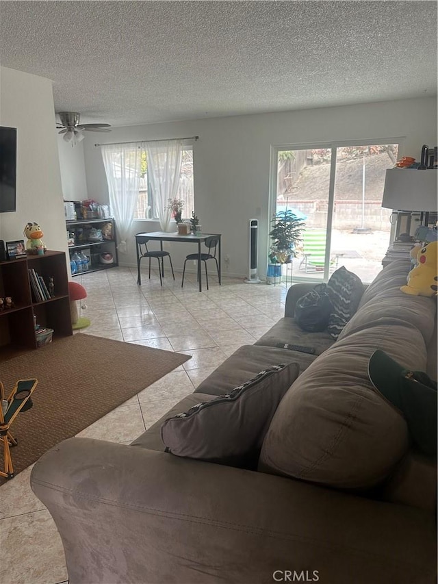 tiled living room with ceiling fan and a textured ceiling