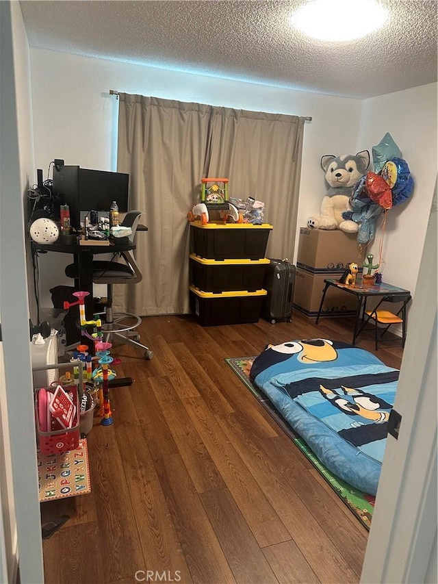 bedroom with wood-type flooring and a textured ceiling