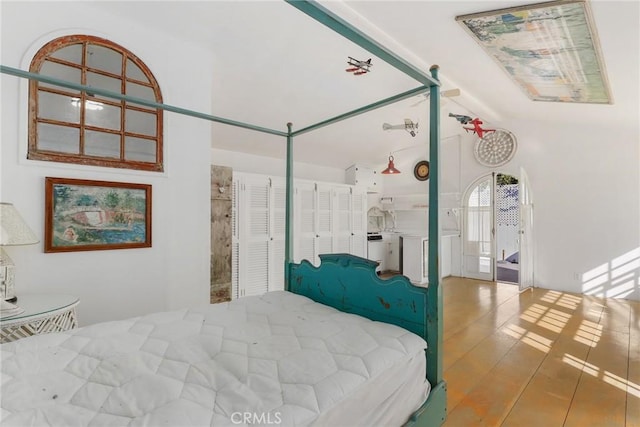 bedroom with lofted ceiling and hardwood / wood-style floors