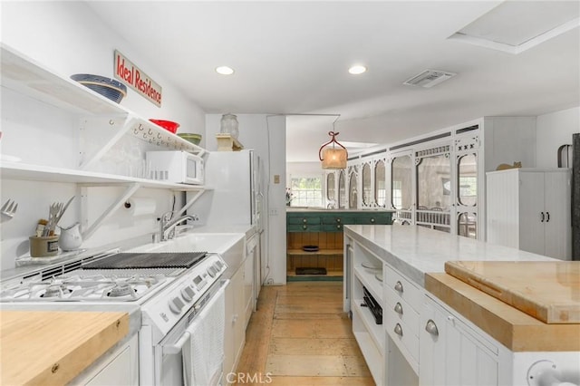 kitchen featuring sink, white appliances, white cabinetry, wood counters, and light wood-type flooring