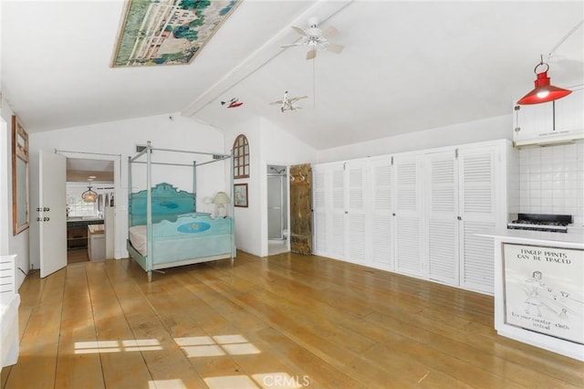 unfurnished bedroom featuring hardwood / wood-style floors, vaulted ceiling with beams, and ceiling fan