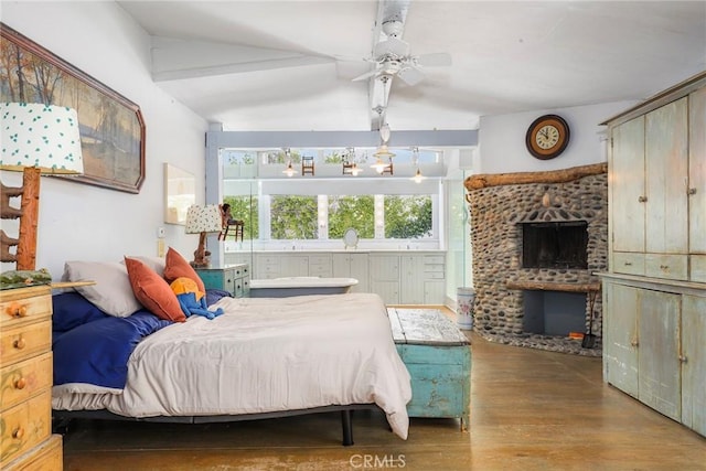 bedroom with a brick fireplace, hardwood / wood-style floors, and ceiling fan