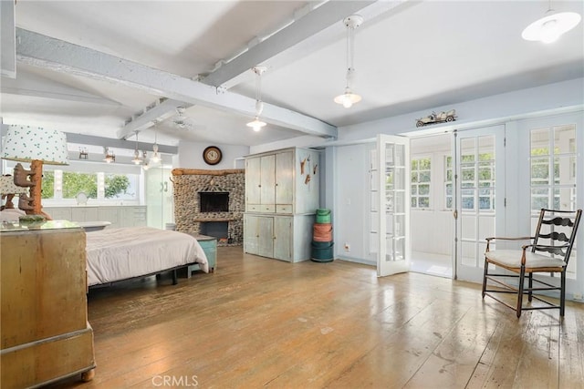 bedroom featuring french doors, wood-type flooring, and beam ceiling