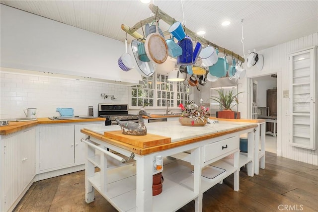 kitchen featuring white cabinetry, stainless steel range, dark wood-type flooring, and butcher block countertops